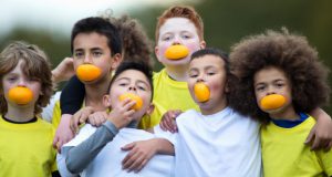 boys with oranges in mouth