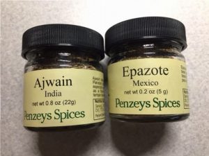 "2 small glass spice jars that read Ajwain and Epazote from Penzeys Spices"