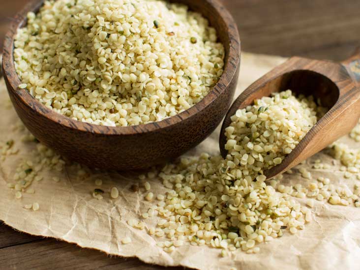 "Wooden bowl and scoop filled with hemp seeds"