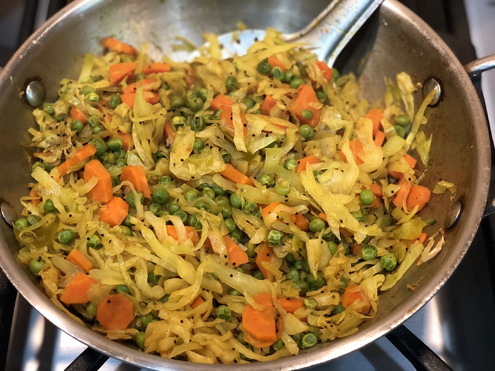 cabbage stir-fry in a steel pan on a gas range