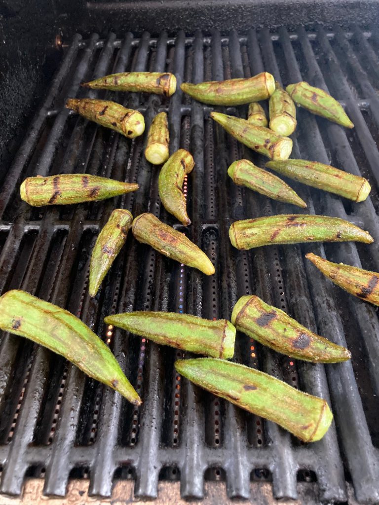 Whole okra on an outdoor grill grate