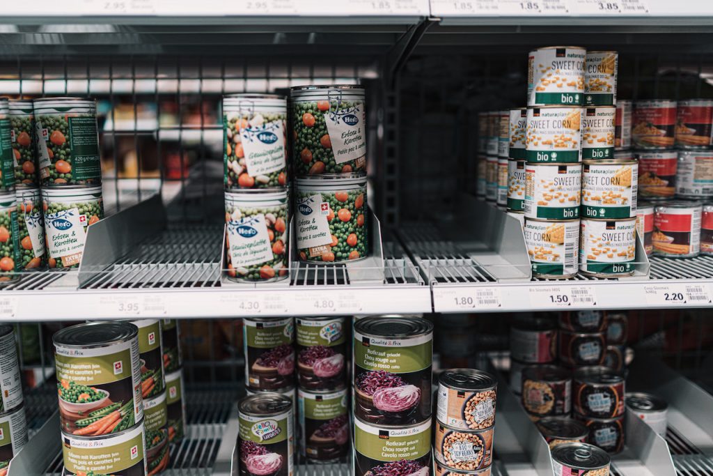 canned vegetables on a wire shelf in a grocery store