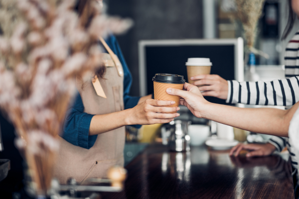 Barista handing a customer their coffee order.