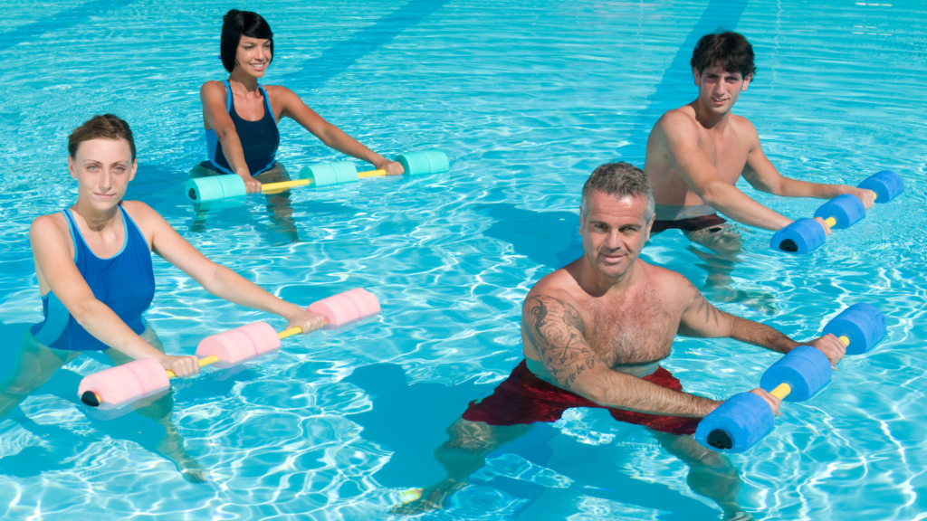a group of people in a swimming pool with floating dumbbells