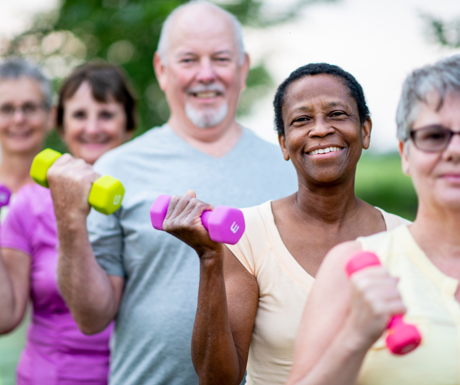 a diverse group of older adults exercising outside with small hand weights